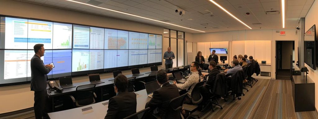 a dynamic and engaging visual captures a diverse group of professionals in a sleek office setting, intently discussing a large display of workers' compensation case studies on a modern screen, illuminated by soft overhead lighting that highlights their analytical expressions and the vibrant graphics of the cases.